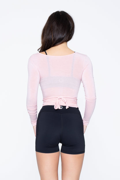 Back shot of model wearing Ruay Muse Reformer wrap top in pink
