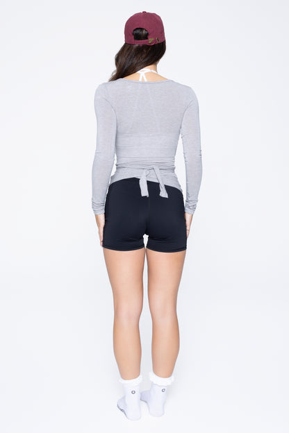 Back shot of model wearing Ruay Muse Reformer Wrap Top in Grey