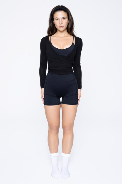 Model wearing Ruay Muse Reformer Wrap Top in Eclipse navy