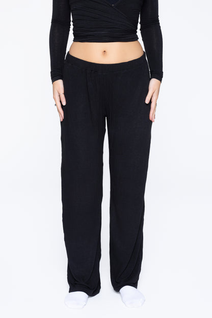 Front shot of model wearing Ruay Muse Reformer trousers in black
