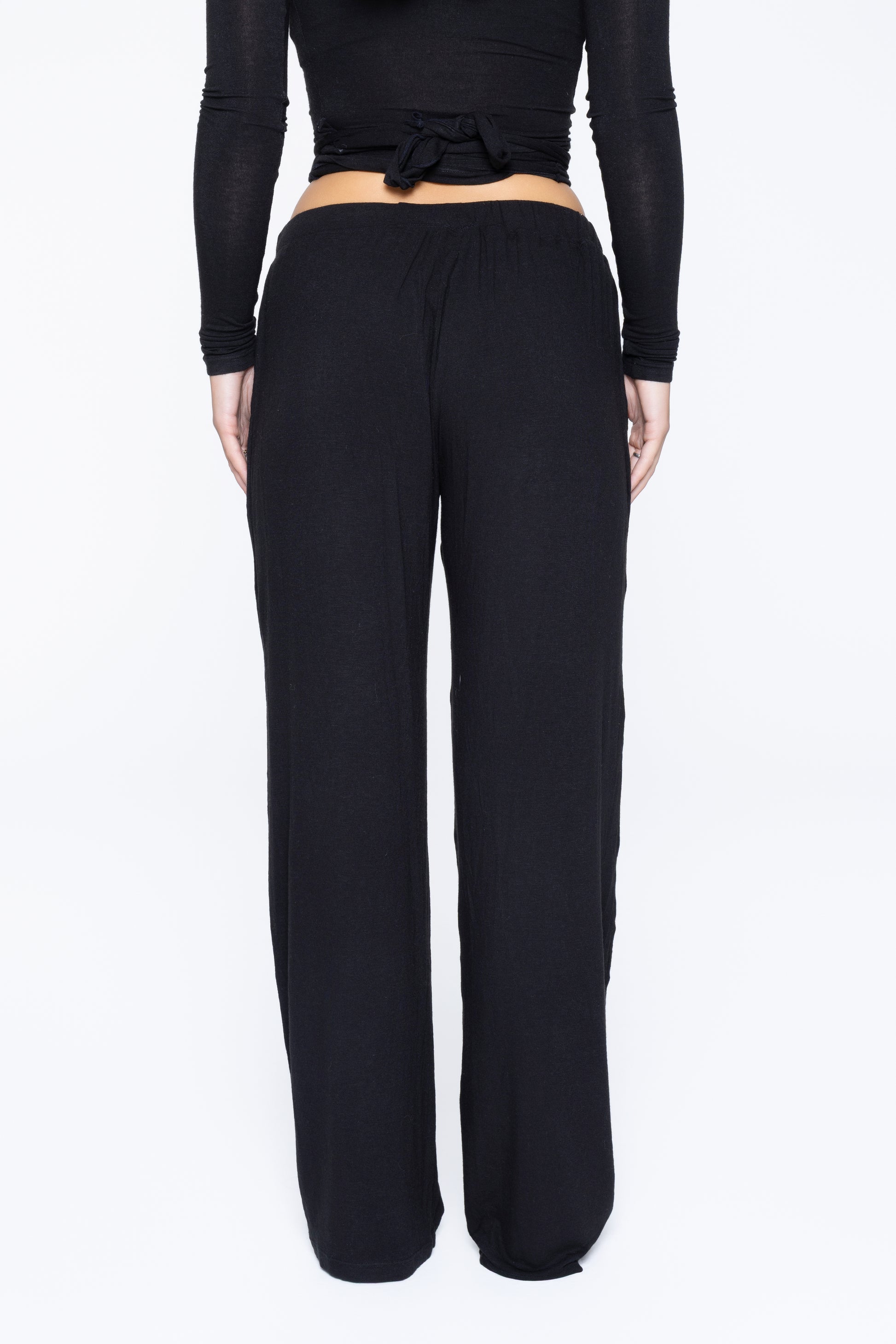 Back shot of model wearing Ruay Muse Reformer trousers in black