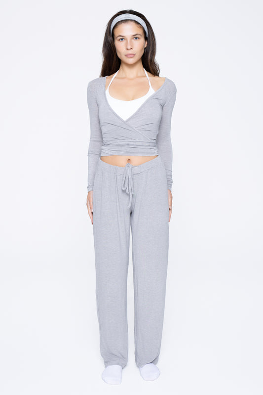 Front shot of model wearing Ruay Muse Reformer wrap top and trousers in grey
