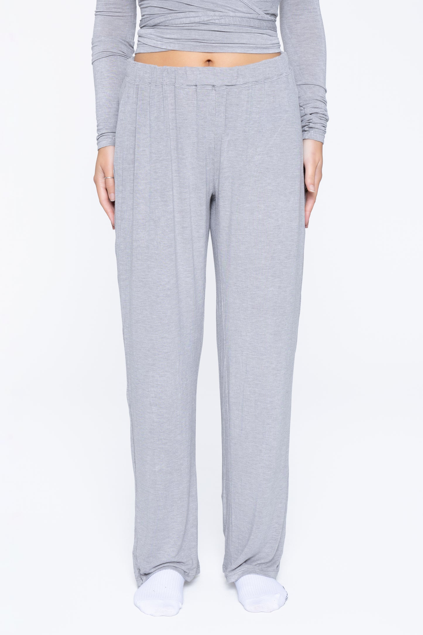 Front shot of model wearing Ruay Muse Reformer trousers in grey