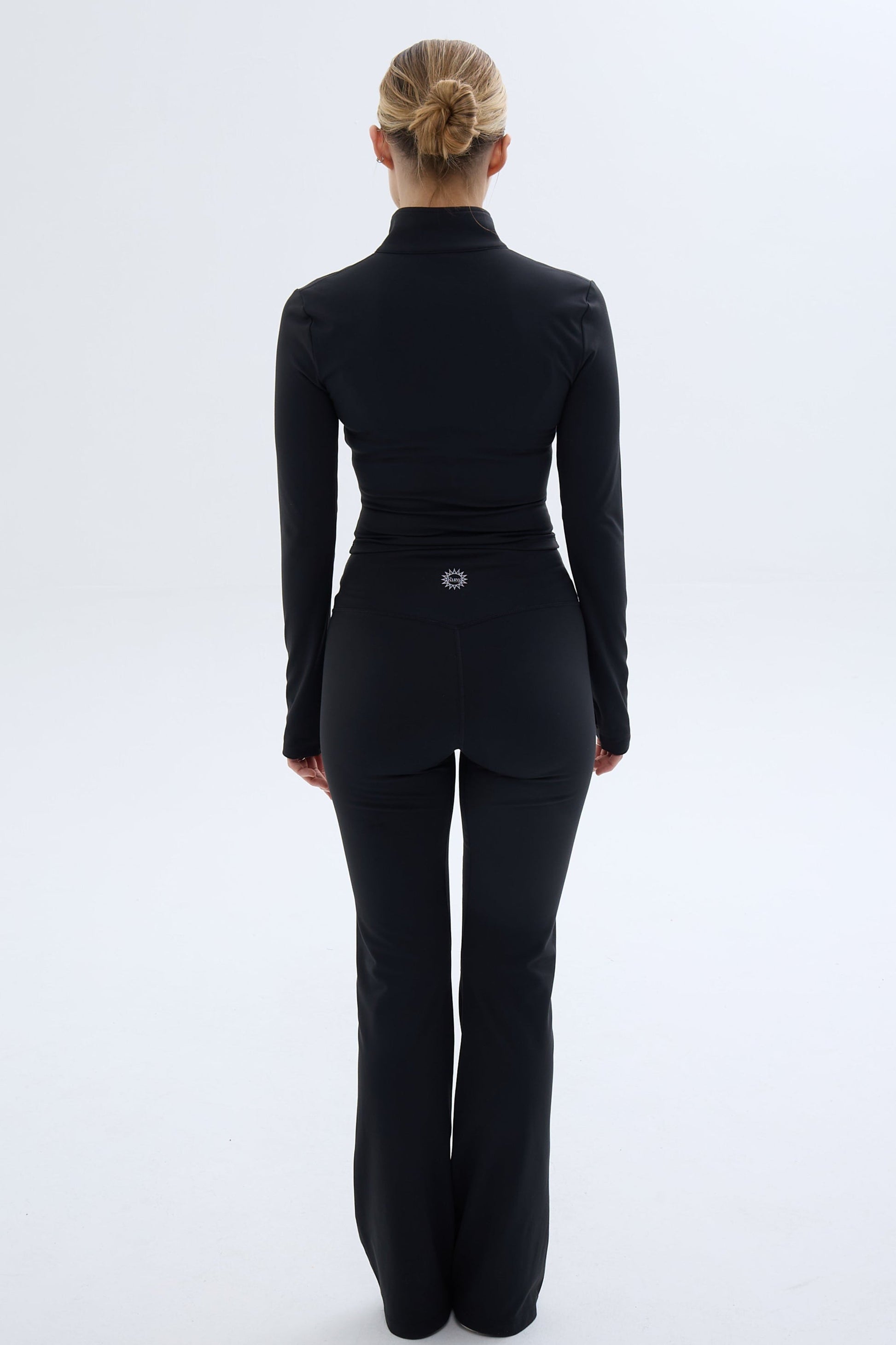 Back shot of model wearing Ruay Muse Silhouet jacket and trousers